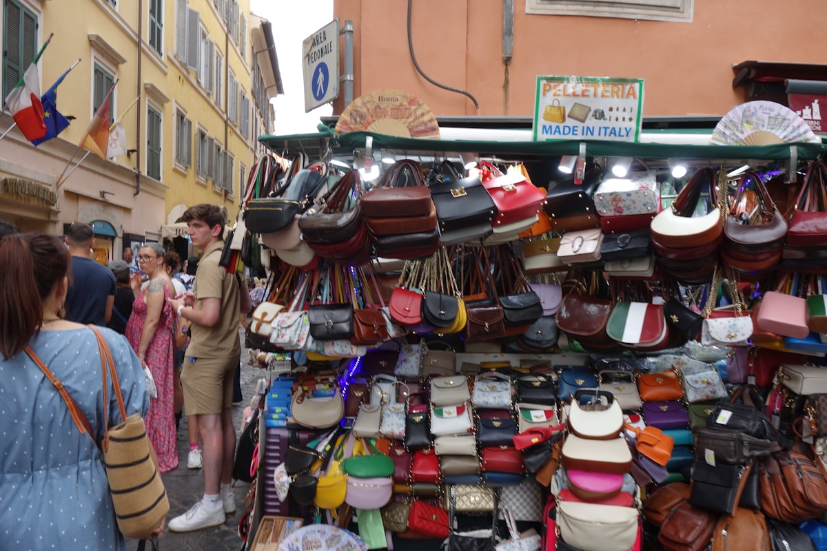 Banca de rua com bolsas de couro empilhadas, como um tabuleiro de feira